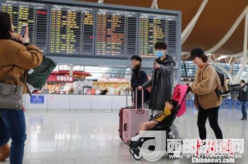 旅客帶著孩子前往辦票柜臺(tái)辦理登機(jī)手續(xù)?！∫罅⑶?攝