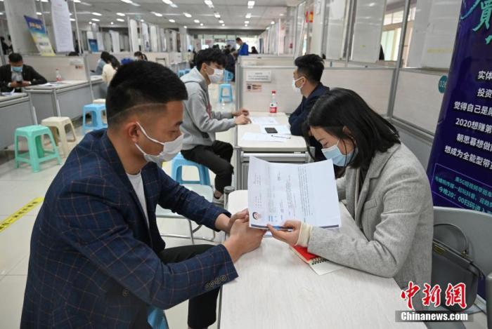 4月14日，招聘者在查看求職者簡(jiǎn)歷。<a target='_blank'  data-cke-saved- >中新社</a>記者 王剛 攝