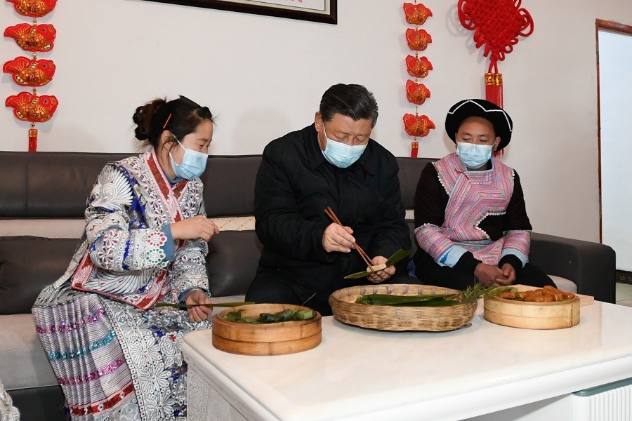 2021年2月3日下午，習(xí)近平在貴州畢節(jié)市黔西縣新仁苗族鄉(xiāng)化屋村苗族村民趙玉學(xué)家，同一家人邊聊家常邊制作當(dāng)?shù)貍鹘y(tǒng)節(jié)日食品黃粑。新華社記者 李學(xué)仁 攝